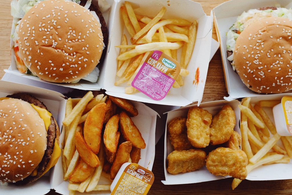 Hamburgers, french fries, potato wedges, chicken nuggets, and sauce packets, all fast food.